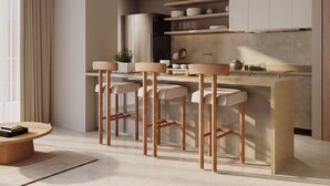 A modern kitchen with a bar area, featuring a central island with stools, a dining table, and a kitchen counter with cabinets. - Praia Suites by Avia Suites (Santa Marta)