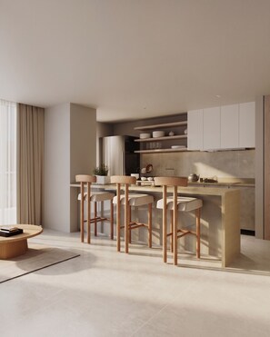 A modern kitchen with a bar area, featuring a central island with stools, a dining table, and a kitchen counter with cabinets.