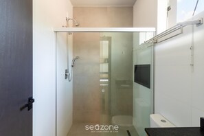Ein modernes Badezimmer mit Duschkabine aus Glas, Toilette und Waschbecken.
