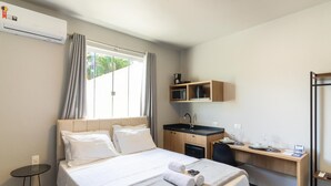 A hotel room with a bed, a desk, a sink, and a window with curtains. - Studio 750m From Vila Germanica Ola0005 (Blumenau)