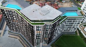 A high-rise building with a rooftop terrace, multiple balconies, and a swimming pool. - Executive Studio at LoxwoodHouse, East Legon (Accra)