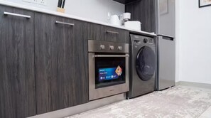A modern kitchen with a built-in oven and a washing machine. - Executive Studio at LoxwoodHouse, East Legon (Accra)