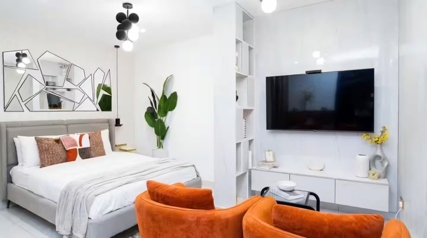 Une chambre à coucher moderne avec un lit, une télévision et un bureau.
