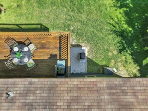 Terraço no telhado com deck de madeira, uma mesa com cadeiras, um espaço de estar pequeno e um elemento de água.