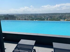 Ein Pool auf dem Dach mit Blick auf die Stadt.