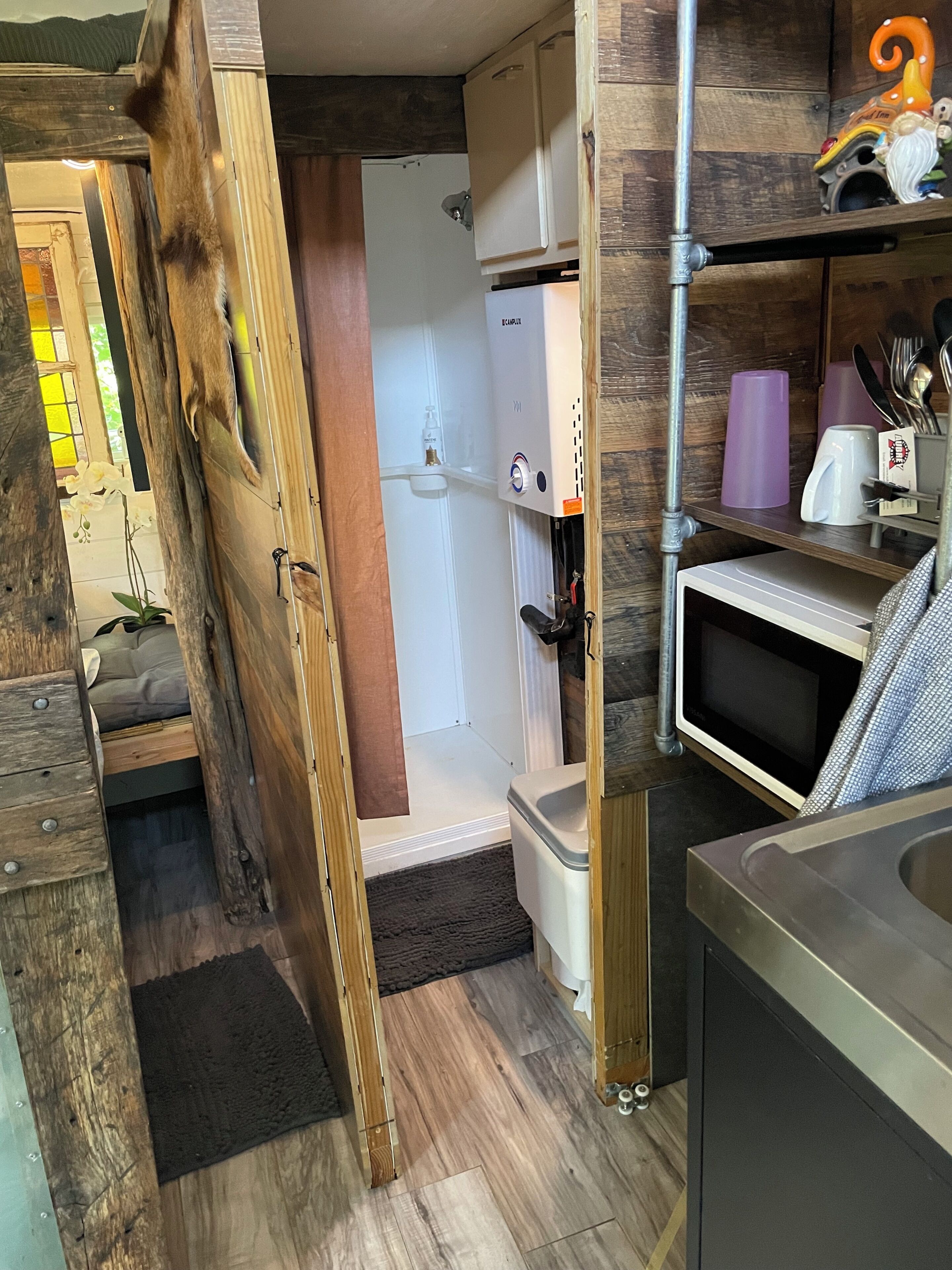 Cocina compacta con microondas, pileta y refrigerador.