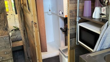 Cocina compacta con microondas, pileta y refrigerador.