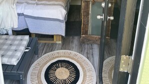 A cozy bedroom with a bed, a small table, and a window with a stained glass design. - Cozy treehouse ! Great kids experience !Or adult ! Fire pit ONLY SLEEPS 2 (Lavon)