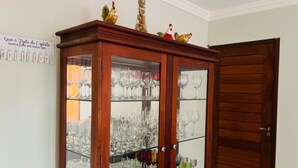 Un meuble en bois doté de portes en verre, renfermant divers objets en verre.