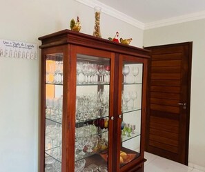 Um armário de madeira com portas de vidro e diversos copos.
