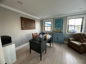 A room with a desk, a leather chair, a globe, and a cabinet. - Spacious 5-Bedroom house on the bay with large dock and open water, sunset views (Brigantine)