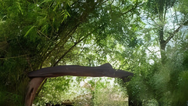 Un arco de madera que conduce a un edificio con base de piedra.