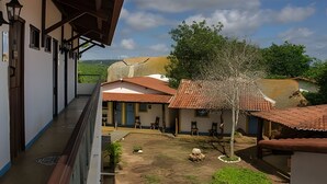Un patio con edificios, un árbol y vistas del paisaje.