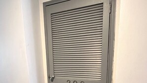Eine Tür mit der Nummer 303, eine schwarze Fußmatte und eine weiße Wand.