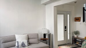 A modern living room with a grey sofa, a black coffee table, a lamp, and a small side table. - Gorgeous 4 Bedroom & 3 Bathroom Townhome Cottage - Blue Mountain (The Blue Mountains)