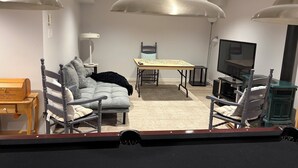 A modern living room with a sofa, chairs, a table, a TV, and a fireplace. - Gorgeous 4 Bedroom & 3 Bathroom Townhome Cottage - Blue Mountain (The Blue Mountains)