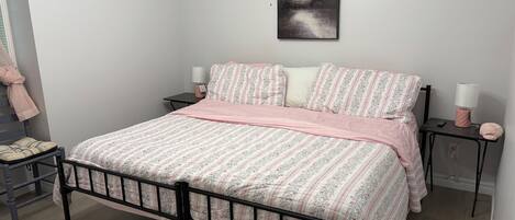 Une chambre à coucher avec un lit, une table de chevet, une lampe et un tableau au mur.