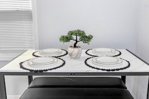 A table set with plates and a vase with a bonsai tree.