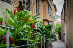 A narrow alleyway with a metal railing, surrounded by buildings with visible windows and balconies. - 4let BH Del Rey (Belo Horizonte)
