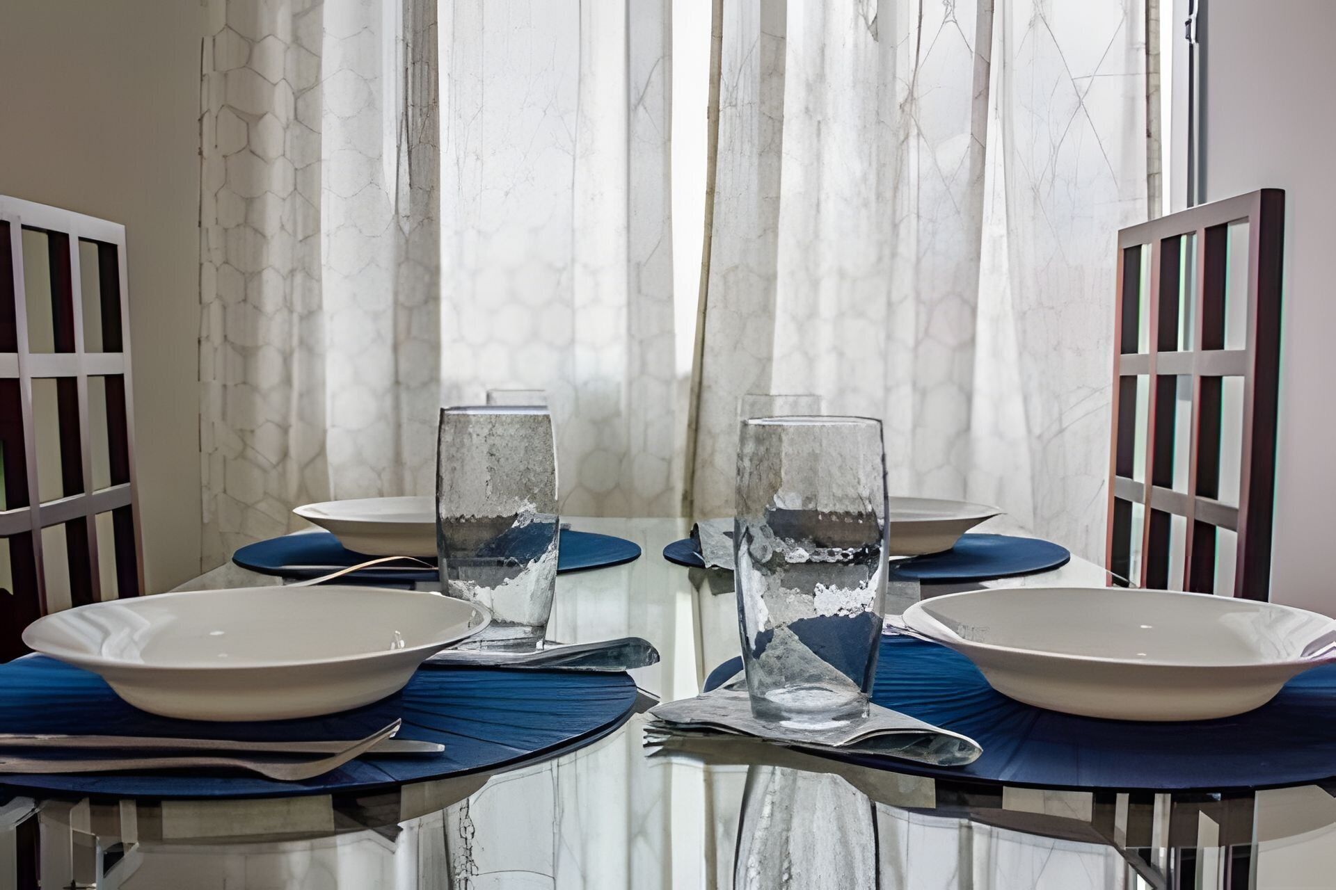 A dining table with two glasses of water, plates, and cutlery.