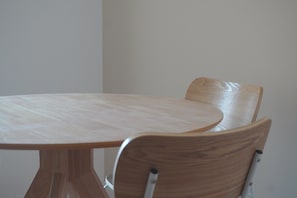 Una mesa redonda de madera con una silla.