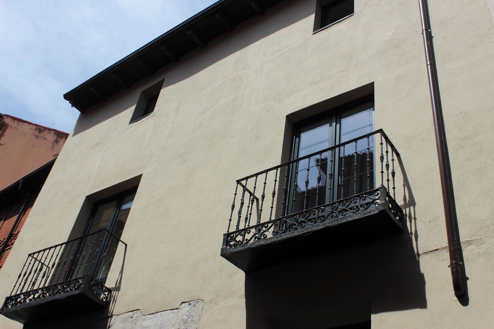 A building with two balconies, each with a wrought iron railing.