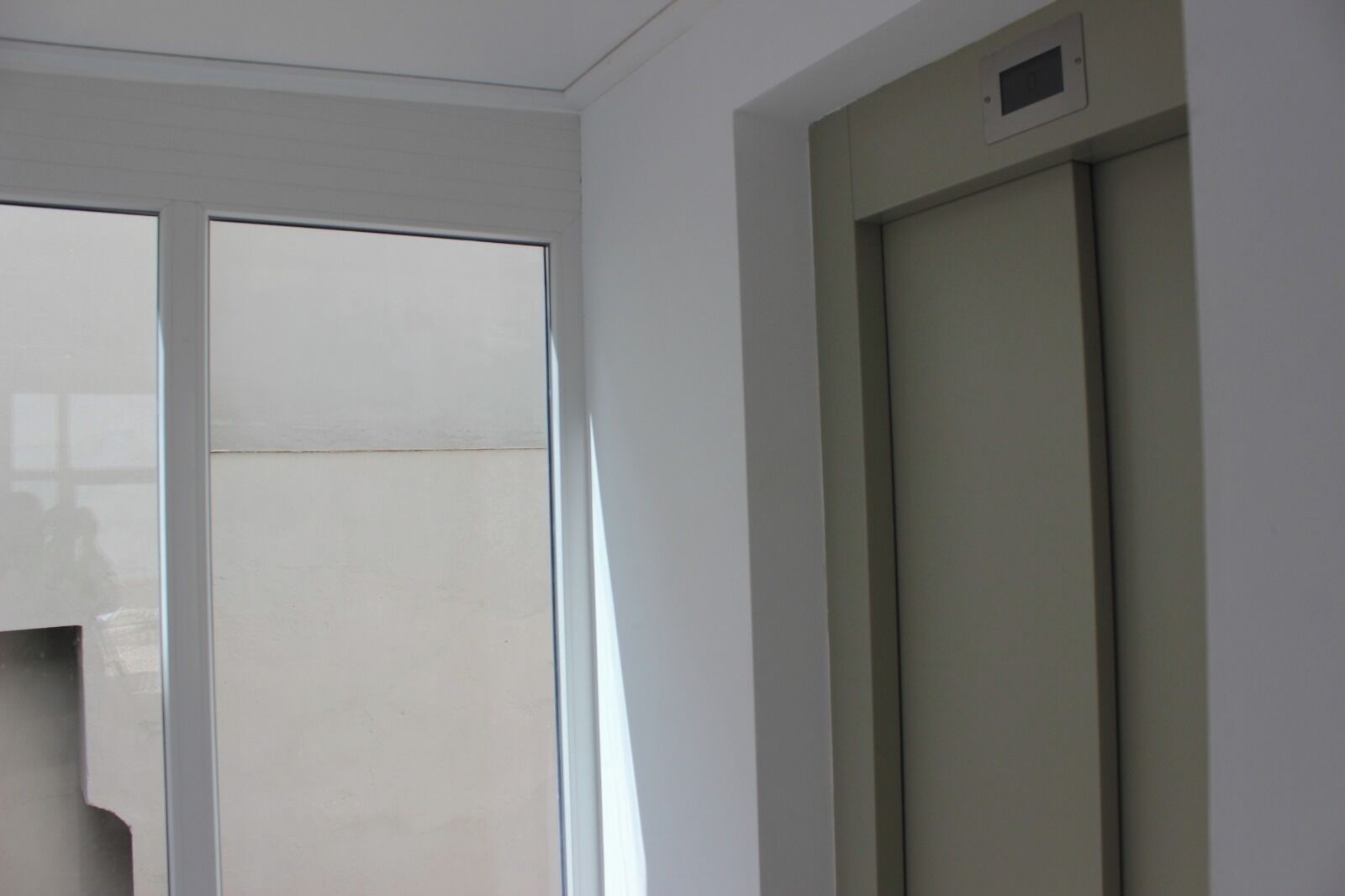 Una habitación con puerta corredera y un respiradero en la pared.