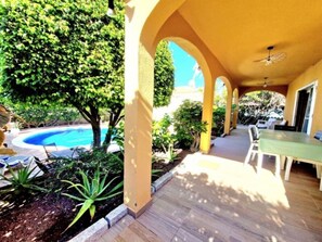 An outdoor patio with a pool, surrounded by greenery and a dining area with a table and chairs. - Sunny Palm Villa | Private Pool | Callao Salvaje (Callao Salvaje)