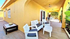 An outdoor patio with white wicker furniture, a small table, and a ceiling fan. - Sunny Palm Villa | Private Pool | Callao Salvaje (Callao Salvaje)