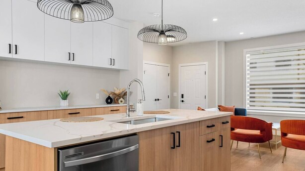 A modern kitchen with a central island, stainless steel dishwasher, and pendant lighting. - 3 King Beds | Min to UofC | Up and Down Combo (Calgary)