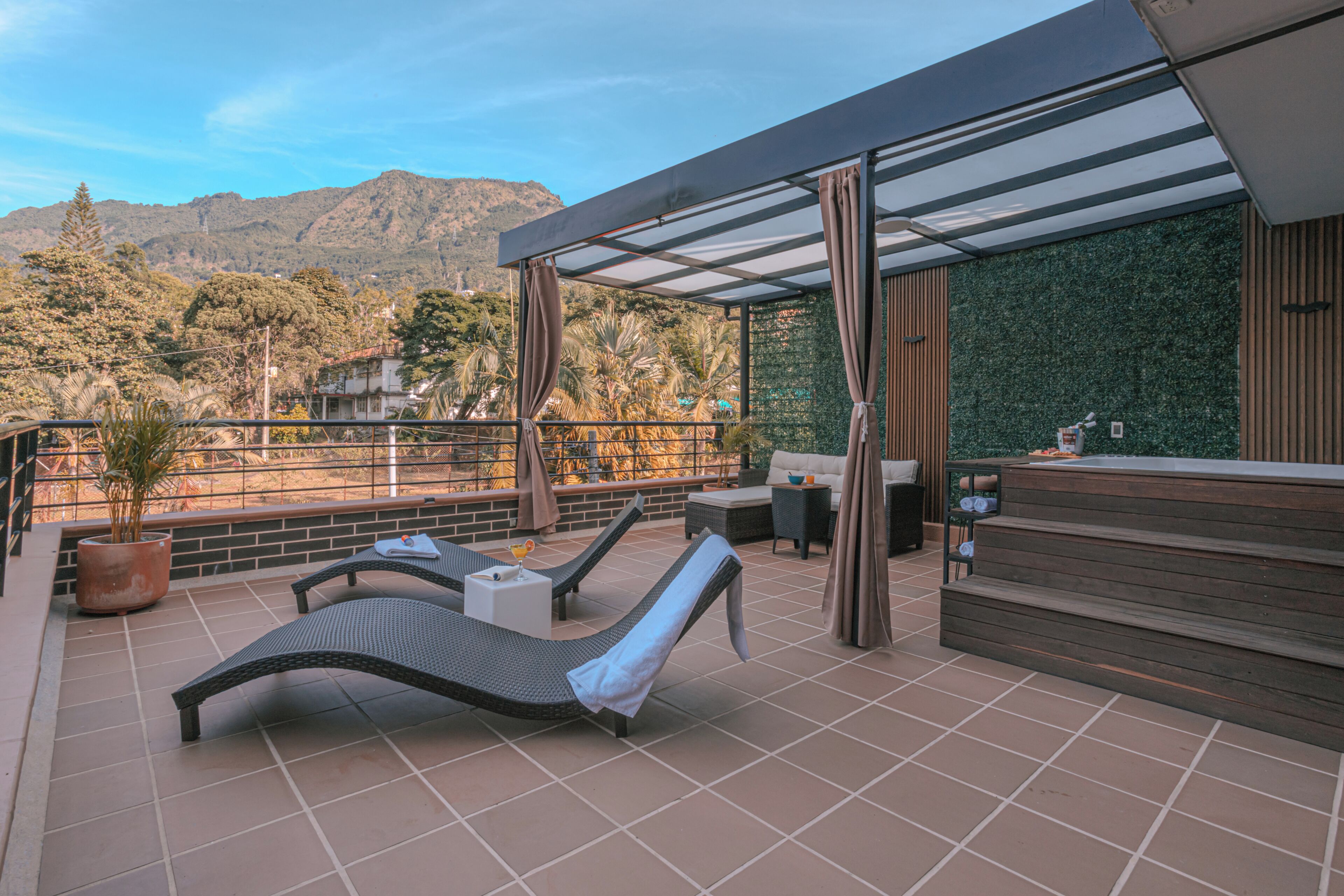 A terrace with lounge chairs, a small table, and a bar area.