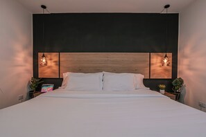 Ein modernes Schlafzimmer mit einem großen Bett, zwei Nachttischen und einem hölzernen Kopfteil.
