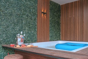 Une salle de bain moderne avec un meuble-lavabo en bois, une baignoire et un mur vert.