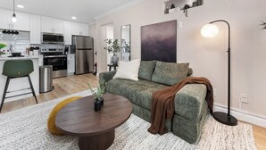 Ett modernt vardagsrum med en soffa, ett soffbord och en golvlampa.