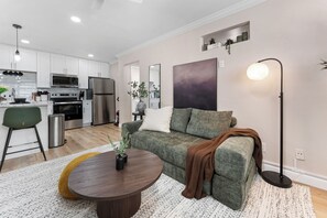 A modern living room with a sofa, a coffee table, and a floor lamp. - Fabulous 1-bedroom apartment with AC in vibrant Houston (Houston)