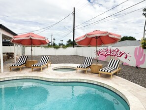 A pool area with lounge chairs and umbrellas, a tiled pool, and a wall with a cactus mural. - Old Town Scottsdale Getaway! Heated Pool + Hot Tub -4BR (Scottsdale)