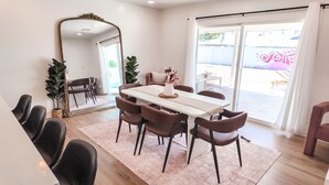 A dining area with a white table, brown chairs, a large mirror, and a view of the outside. -  Resort-Style Oasis Near Old Town Scottsdale (Scottsdale)