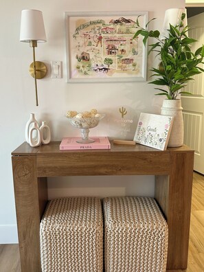 A wooden console table with a framed map, a vase with decorative balls, a 'Welcome to' sign, and a 'Guests' sign. - Old Town Scottsdale Getaway! Heated Pool + Hot Tub -4BR (Scottsdale)