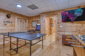 Ein Raum mit Tischtennisplatte, Kicker und Spielmaschine.