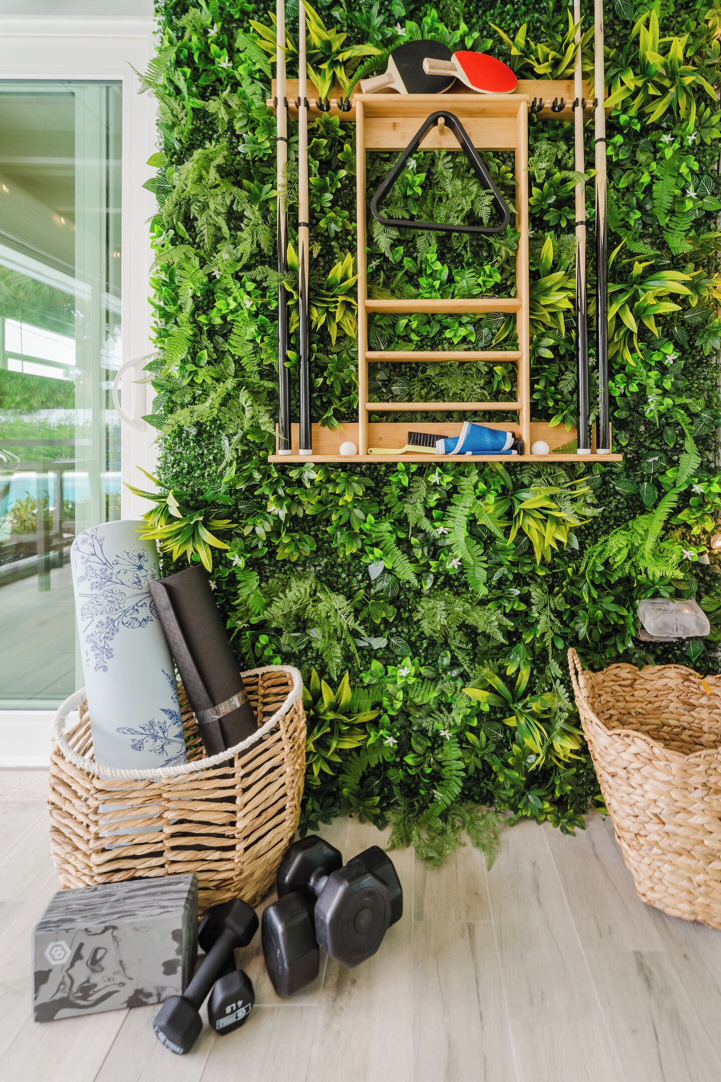 Una pared con jardín vertical, una escalera de madera y equipo de ejercicio.