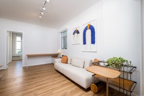 A modern living room with a sofa, a wooden table, and a plant. - Modern Apartment in the Center of Floripa Vlr301 (Florianópolis)
