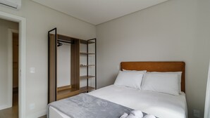 Ein Schlafzimmer mit einem Bett, einem Holzschrank und einem weißen Kopfteil.