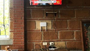 A television mounted on a brick wall with a table in front. - Tranquil 3-bedroom house in joyas de agua  perfect for relaxing courtesy coffee (Emiliano Zapata)