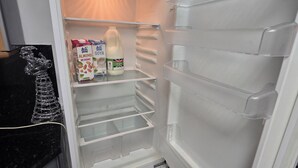 An open refrigerator with a milk carton, a carton of almond milk, and a bottle of milk. - Private & Charming Annex. Wi-Fi, Free parking, 15 min to Swindon Designer shops. (Highworth)