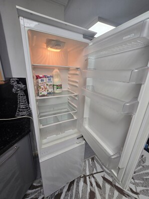 An open refrigerator with a milk carton, a carton of almond milk, and a bottle of milk. - Private & Charming Annex. Wi-Fi, Free parking, 15 min to Swindon Designer shops. (Highworth)
