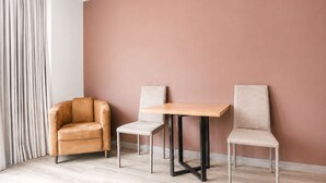 A room with a light-colored wooden floor, a brown leather sofa, a small wooden table with metal legs, and two matching chairs. - 2-bedroom apartment in lovely Bogotá with fitness room access (Bogotá)