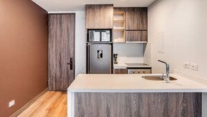 A modern kitchen with a built-in refrigerator, a sink, and wooden cabinetry. - 2-bedroom apartment in lovely Bogotá with fitness room access (Bogotá)