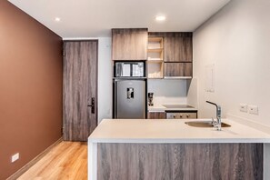 Eine moderne Küche mit integriertem Kühlschrank, einer Spüle und Holzschränken.