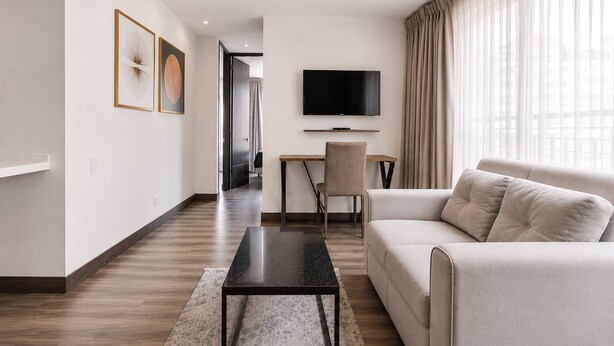 A modern living room with a sofa, a coffee table, a TV, and a desk. - 2-bedroom apartment in lovely Bogotá with fitness room access (Bogotá)