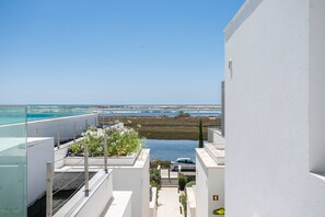 Ein modernes Gebäude mit Meerblick und einem kleinen Wasserspiel.